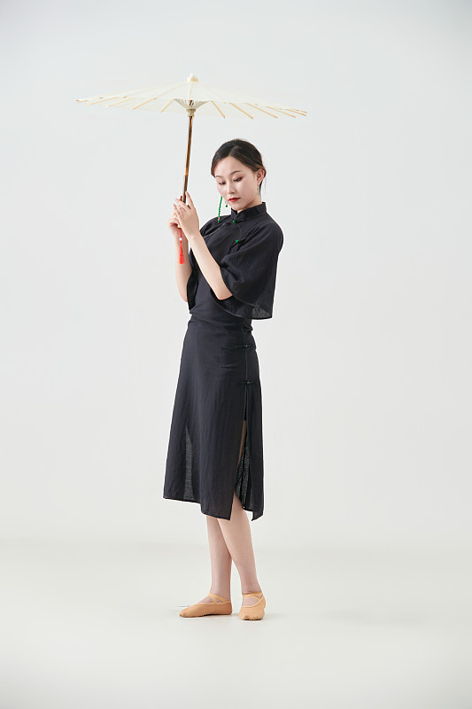 穿中式旗袍手拿油纸伞翩翩舞蹈的亚洲少女舞者图片下载
