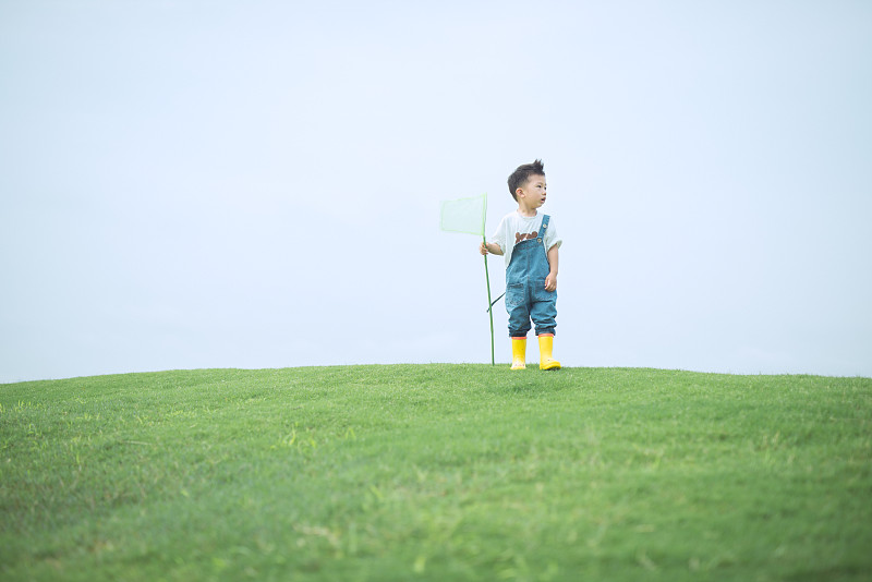 男孩站在草坪上图片下载