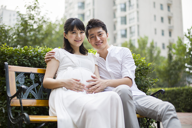 孕妇和丈夫坐在长椅上图片下载