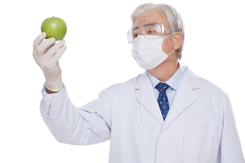 一个老年医生拿着青苹果图片素材