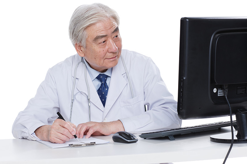 一个老年医生坐在医生办公室图片下载