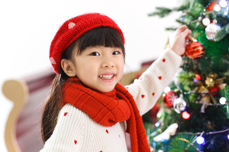 可爱的小女孩在装饰圣诞树图片素材