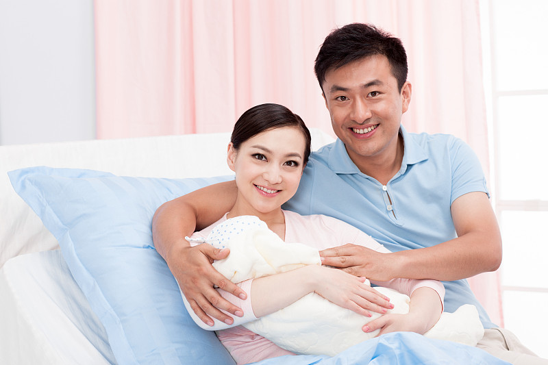 年轻夫妇抱着婴儿图片下载