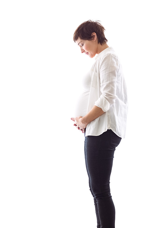 一个孕妇抱着她的小腹在白色的背景上图片下载