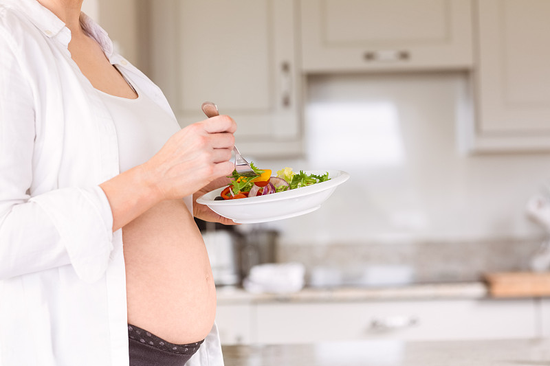 孕妇在家厨房里吃沙拉图片下载