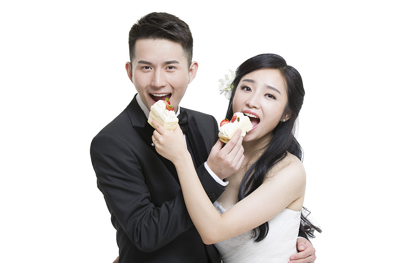 快乐的新娘和新郎吃蛋糕图片下载