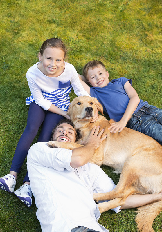 家人和狗在草坪上放松图片下载