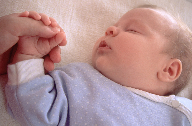 熟睡的小男孩握着妈妈的手指图片下载