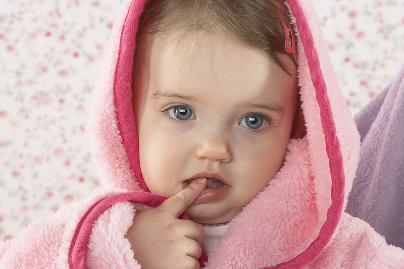 抱着穿粉红色浴袍的婴儿的女人图片素材