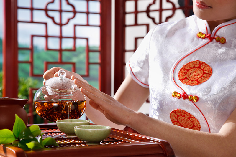 一个东方女孩在茶园的茶舍喝茶图片素材