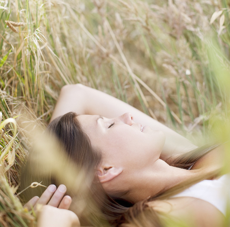 睡在草地上的安详女人图片下载