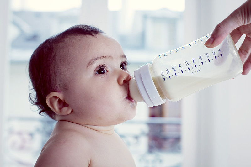婴儿用奶瓶喝牛奶图片下载