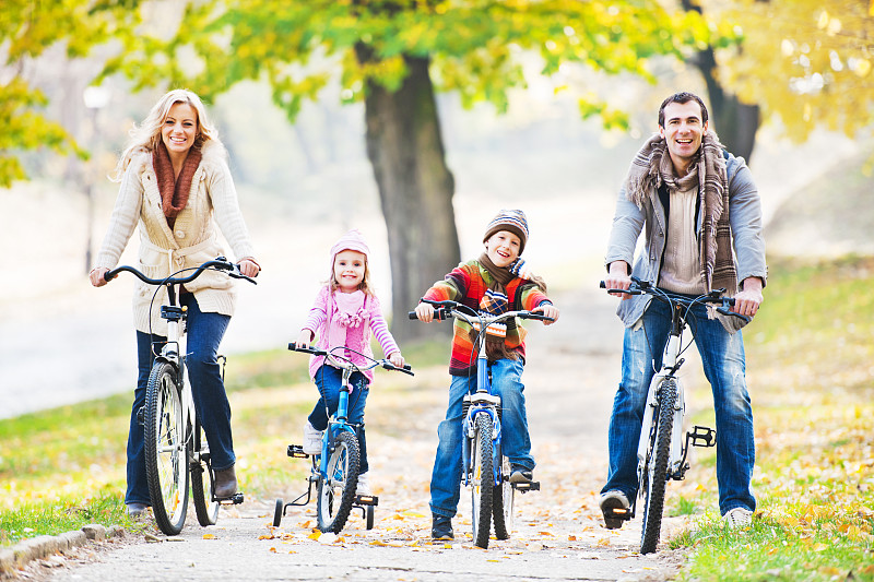 快乐家庭在大自然中骑自行车。图片下载