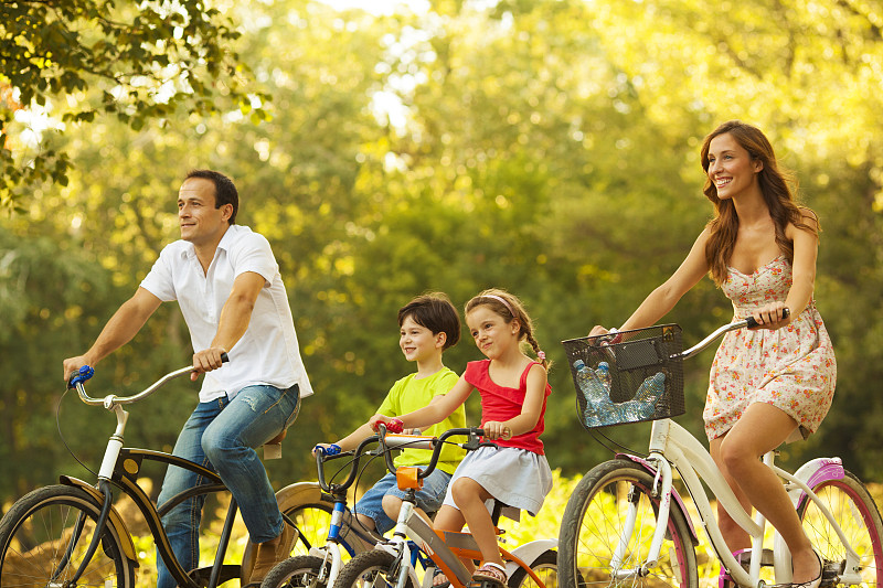 快乐家庭户外骑自行车。图片下载