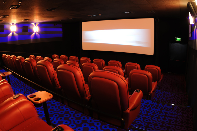 一排排面向电影屏幕的红色电影院座位图片素材