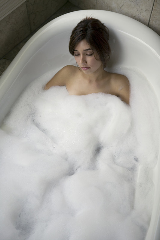 在泡沫浴中放松的女人，俯瞰高处图片下载
