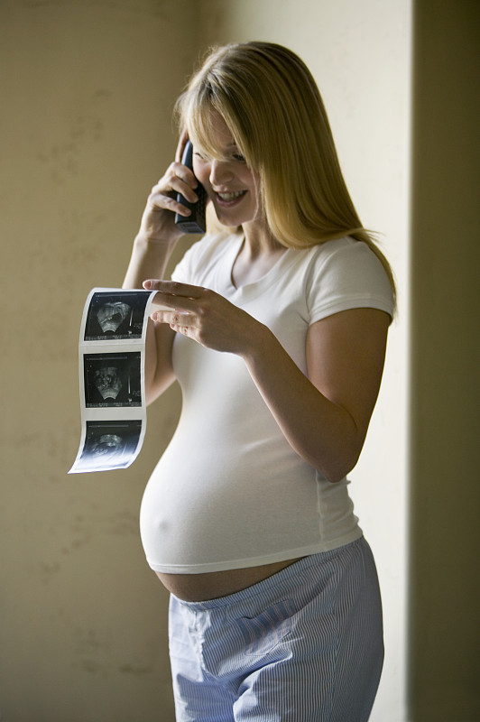 孕妇使用手机，手持超声波打印，室内图片下载