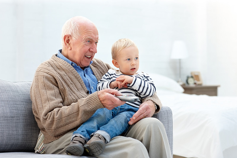 放松的爷爷和孙子看电视图片下载