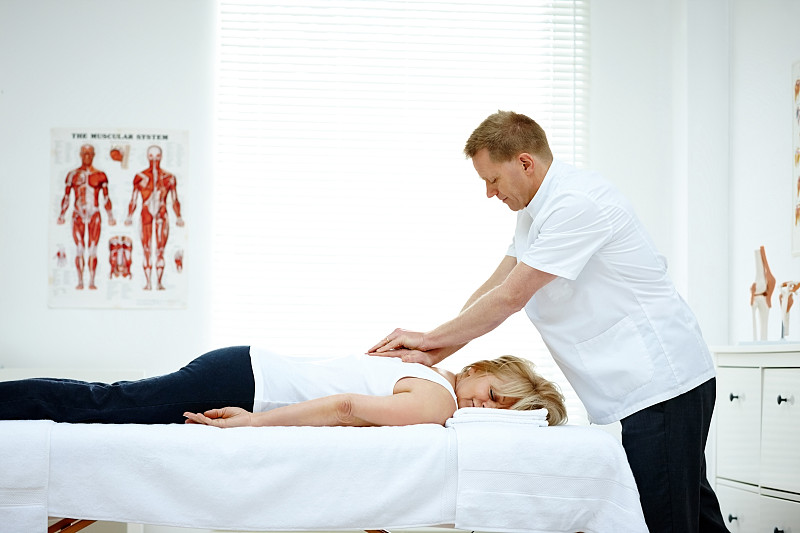 男性整骨医生治疗一个女人的背部问题图片素材