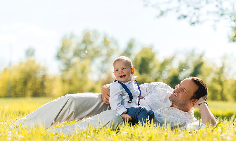 快乐的父亲和他的可爱的男孩在公园里享受。图片下载