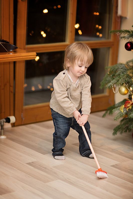 蹒跚学步的孩子在圣诞节尝试他的新玩具图片下载