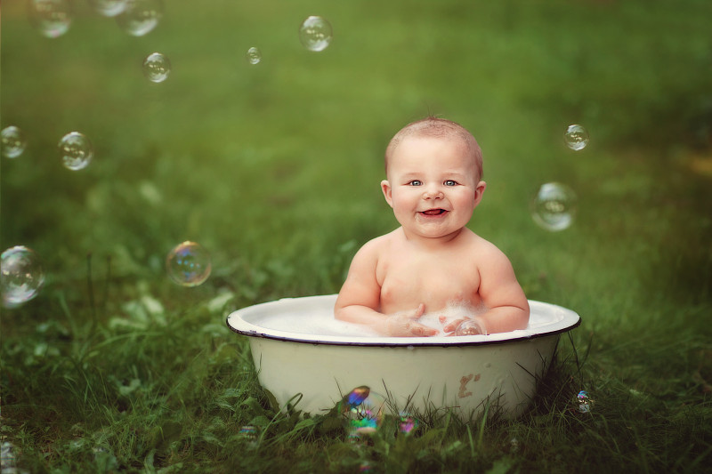 小婴儿坐在有泡泡的洗脸盆里图片下载
