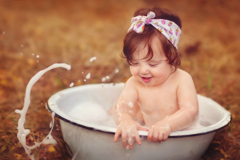 小女孩在户外的洗脸盆里溅水图片下载