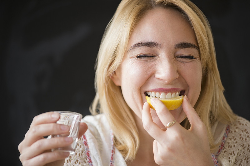 白种女人吃着柠檬片配烈酒图片素材