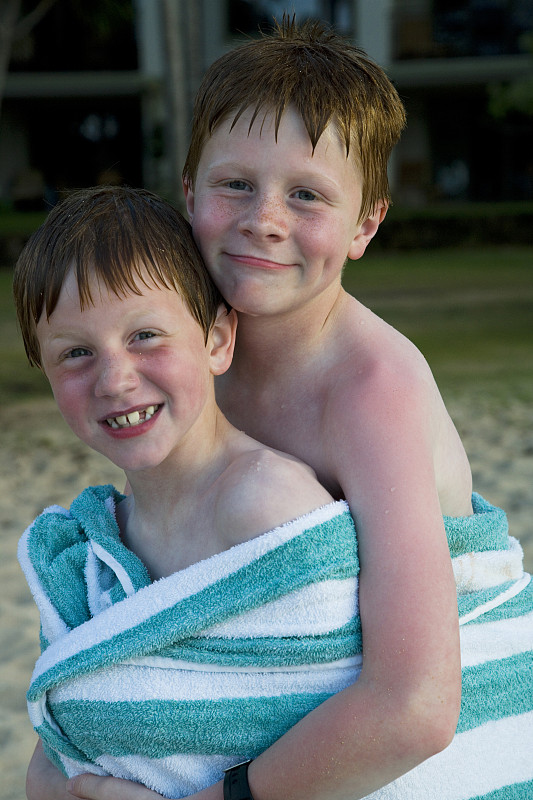 两个男孩裹着毛巾在户外微笑图片下载