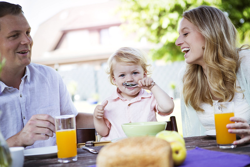 幸福的一家人坐在早餐桌旁图片下载