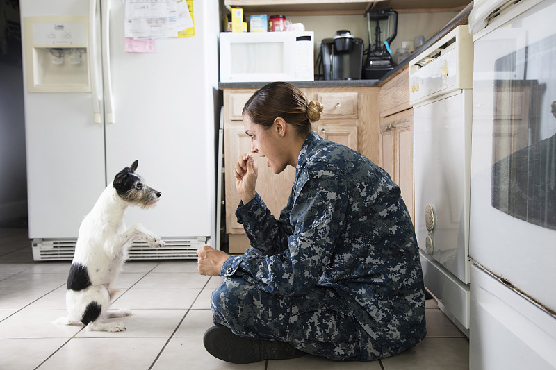 一个军人和她的宠物狗在家里图片下载