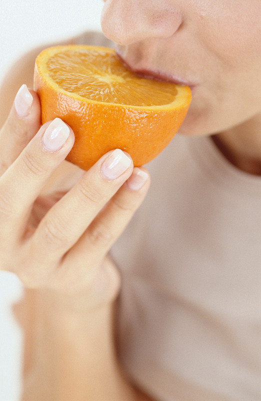 Woman eating orange图片素材