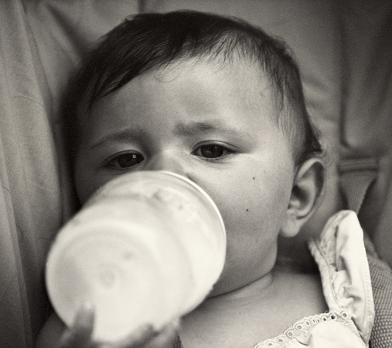 小女孩喝着奶瓶里的牛奶图片下载