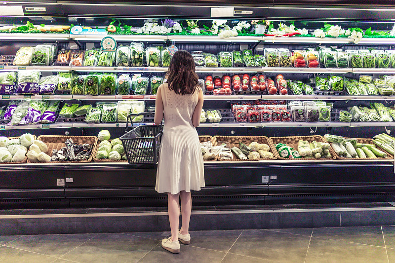 年轻的亚洲女性在超市选择新鲜的有机蔬菜。图片下载
