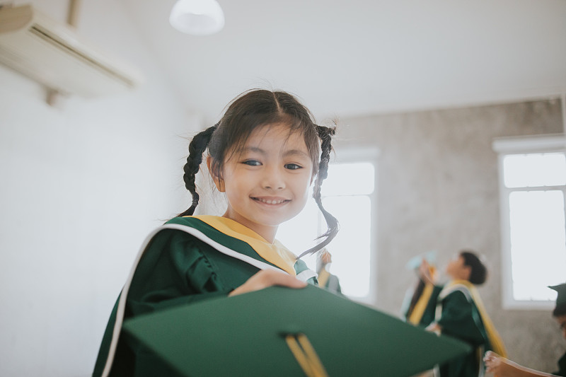 泰国可爱的宝贝女孩收到她的毕业帽与毕业日股票照片摄影图片下载