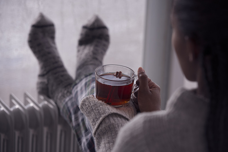 后面是一个女人在阴冷潮湿的天气在家喝茶的画面。图片下载
