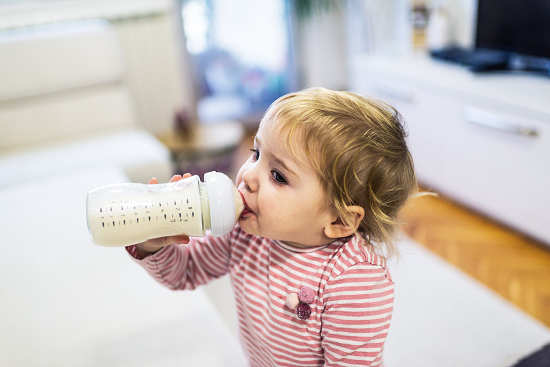 小女孩在喝瓶子里的牛奶图片下载