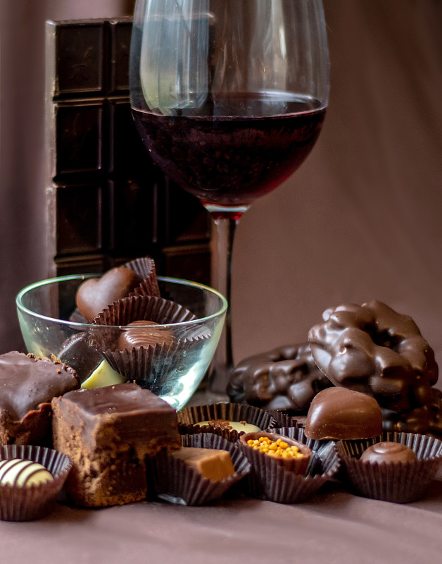 红酒红酒课的周围是各种各样的巧克力，糖果饼干和蛋糕图片素材