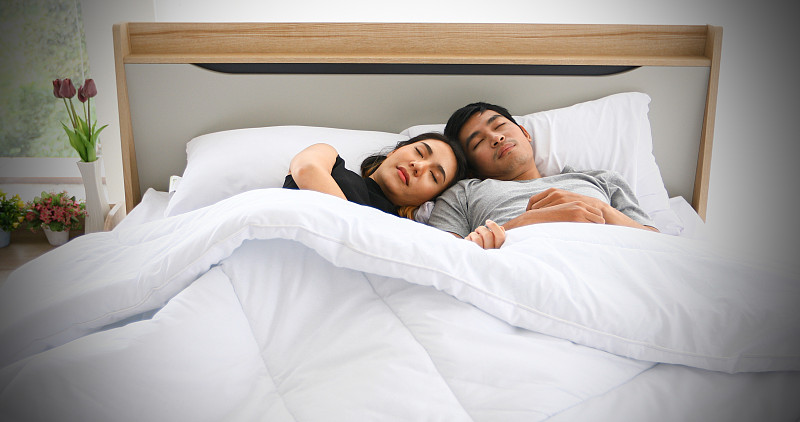 在家里的床上睡觉的微笑夫妇图片素材