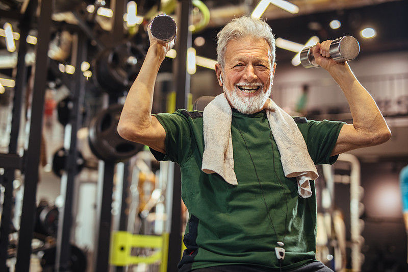 一个老男人在健身房练哑铃图片下载