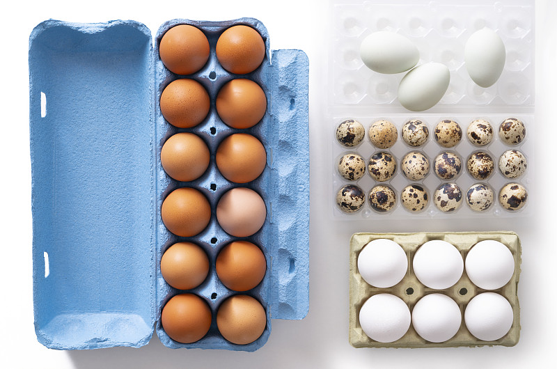 一打棕色鸡蛋纸盒，六个白鸡蛋和鹌鹑蛋放在白纸盒上图片下载