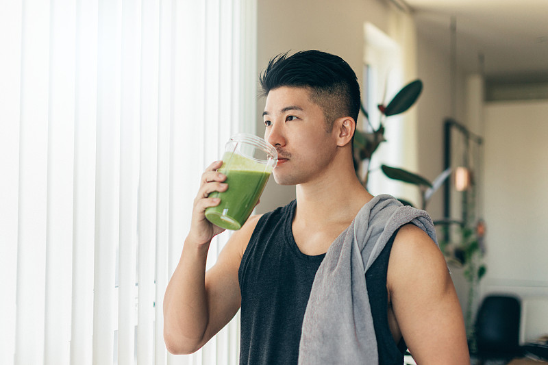 自信的亚洲男人在锻炼后喝蛋白质奶昔图片下载