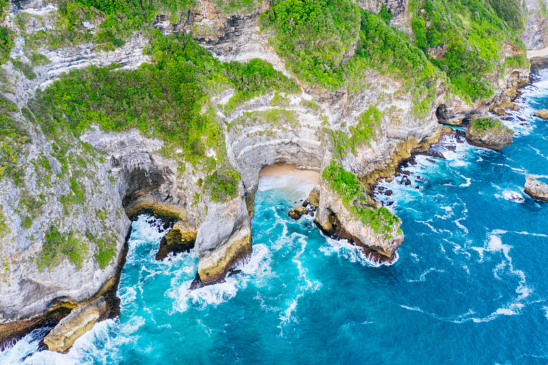 蓝色的海洋和被热带植物覆盖的悬崖。从上面看巴厘岛海岸。空中无人机拍摄。图片下载