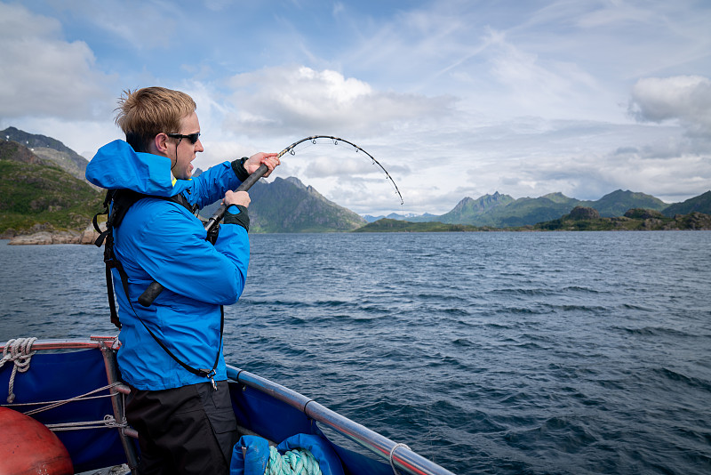挪威斯沃尔韦尔，一名白人男子试图抓一条鱼图片素材