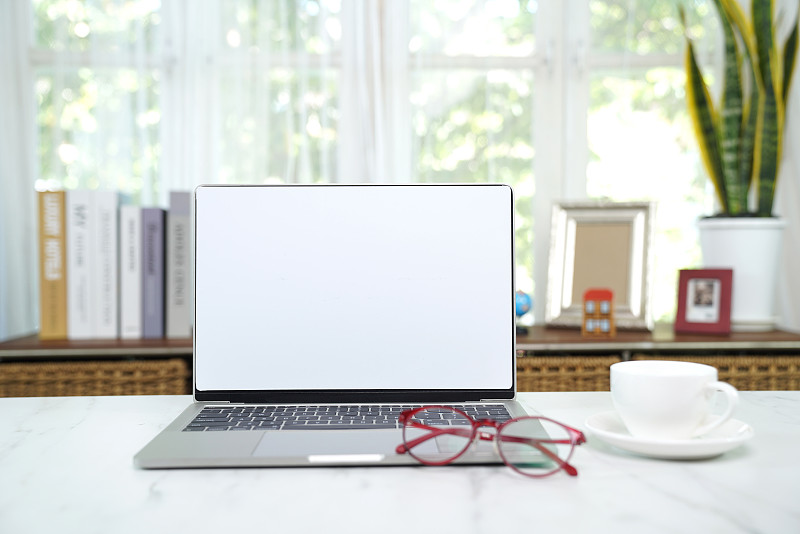 空白色屏幕的笔记本电脑，家庭办公桌图片素材