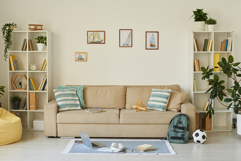 室内舒适的客厅与孩子的东西和船照片上面的沙发，房子的设计理念摄影图片