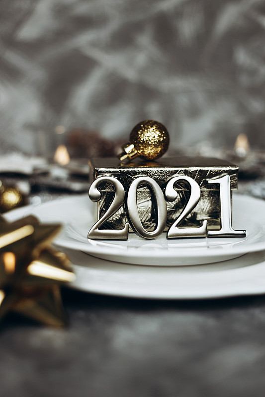 白色漂亮的盘子与金色圣诞玩具，2021年的数字在盘子上图片下载