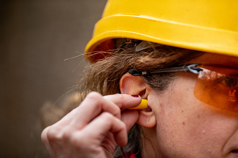 成年女工插入耳朵保护器的特写图片下载