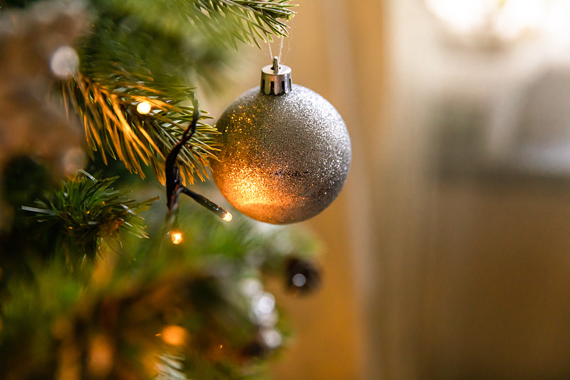 经典的圣诞装饰新年树。用白色和银色装饰的圣诞树，装饰玩具和球。现代古典风格的室内设计公寓。平安夜在家图片下载