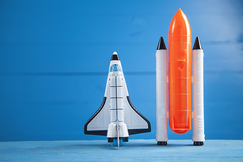 蓝色背景上的玩具航天飞机。火箭发射图片下载